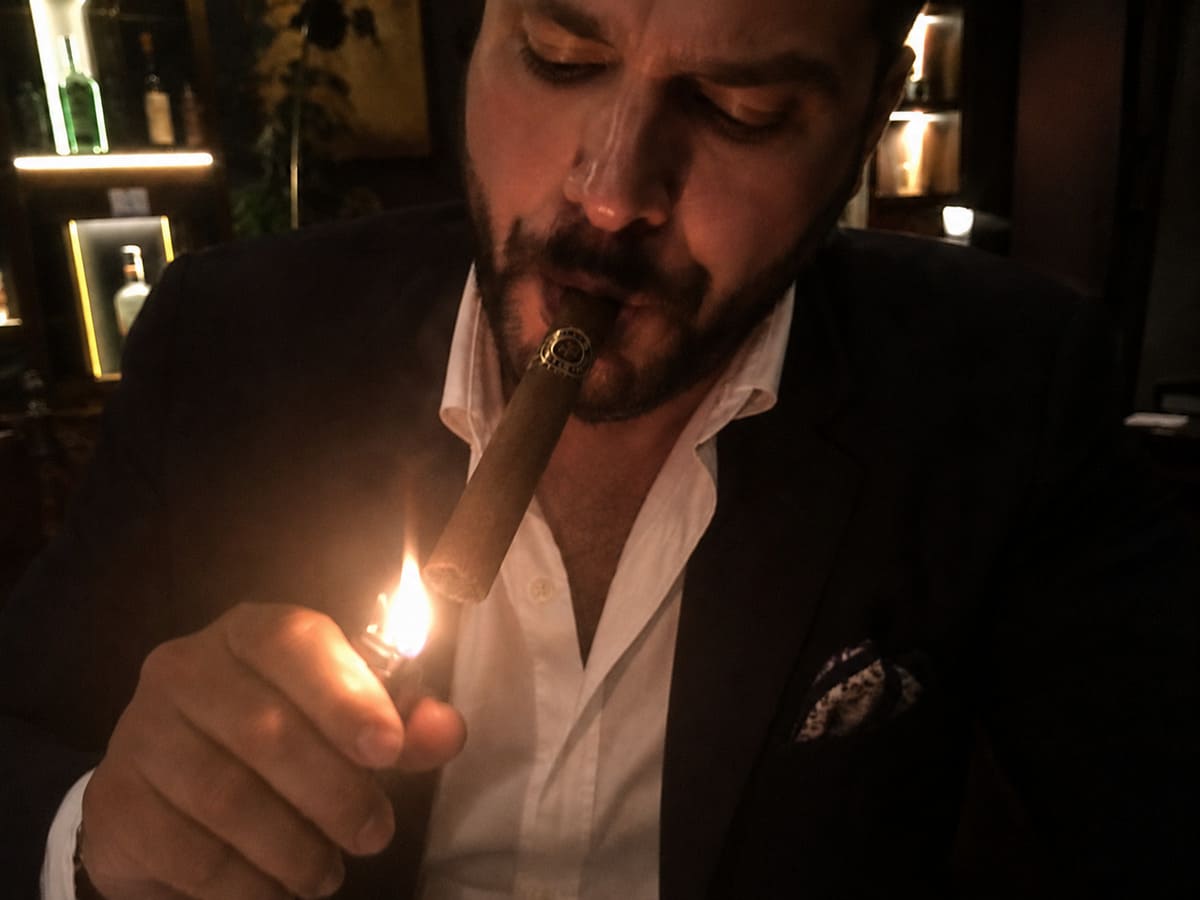 man lighting a cigar